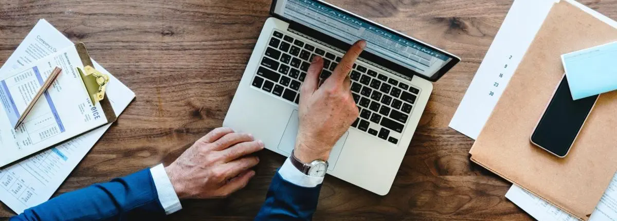 Man pointing to a blog on a laptop